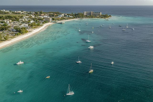 an aerial image of a bay, speckled with boats.